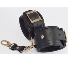 Черные кожаные наручники с золотистыми пряжками и карабином